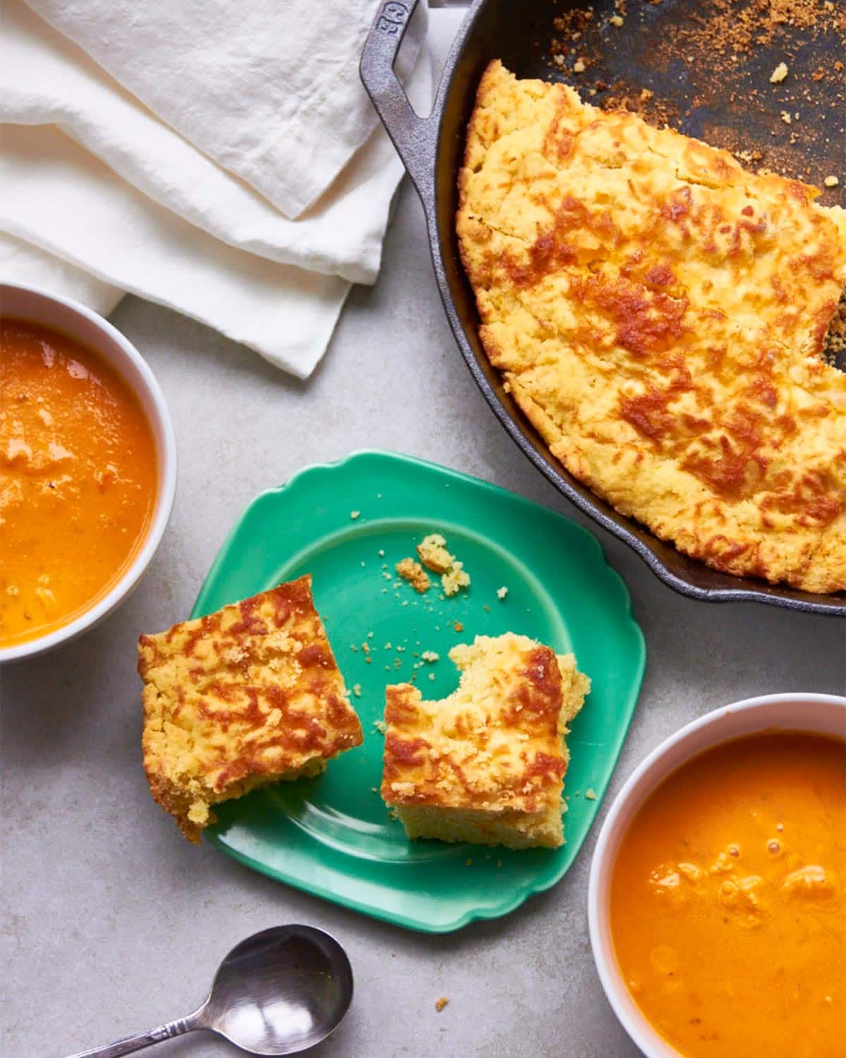 Cheddar Cornbread with soup on table.