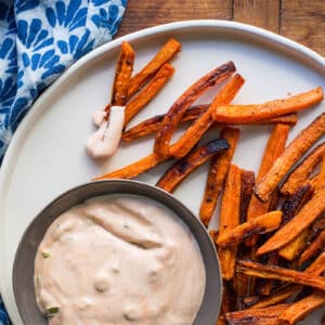 Carrot Fries on plate with bowl of Sriracha Sauce.