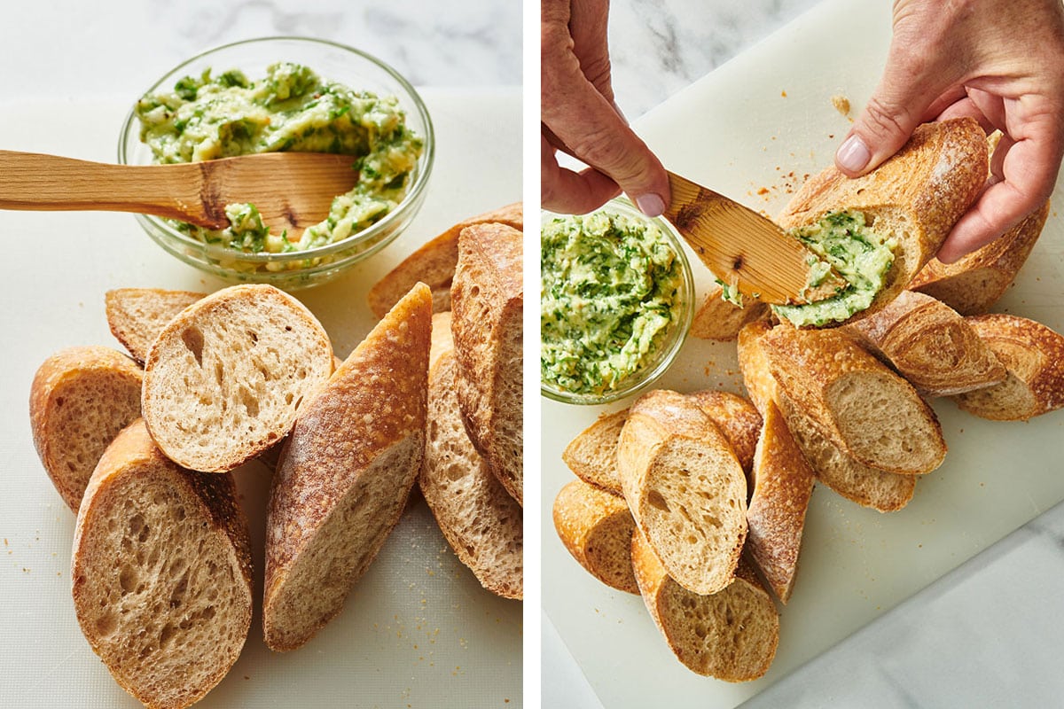 Smearing garlic butter on sliced baguettes over cutting board.