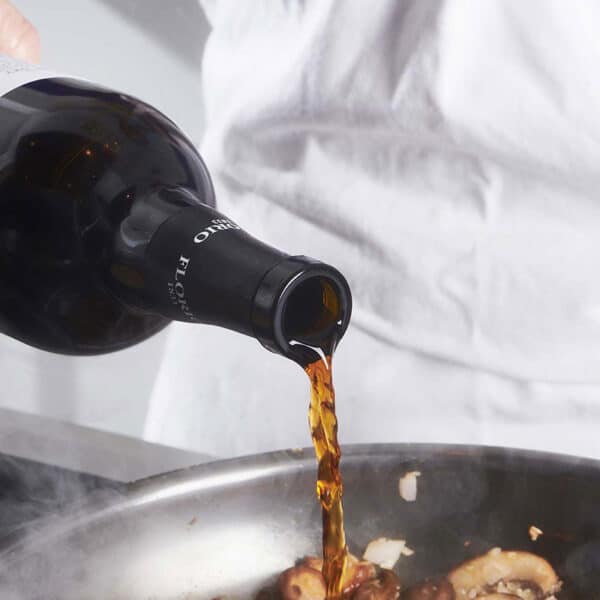 Pouring Marsala wine into pan of food.