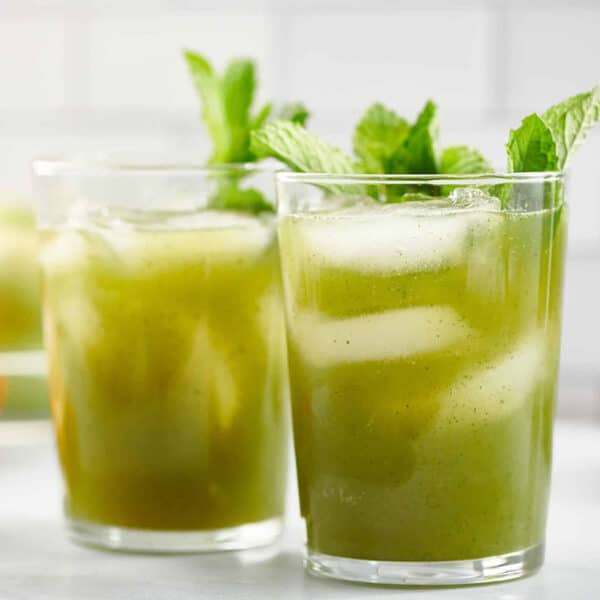 Two small glasses of Vodka Prosecco Cocktail topped with mint leaves.