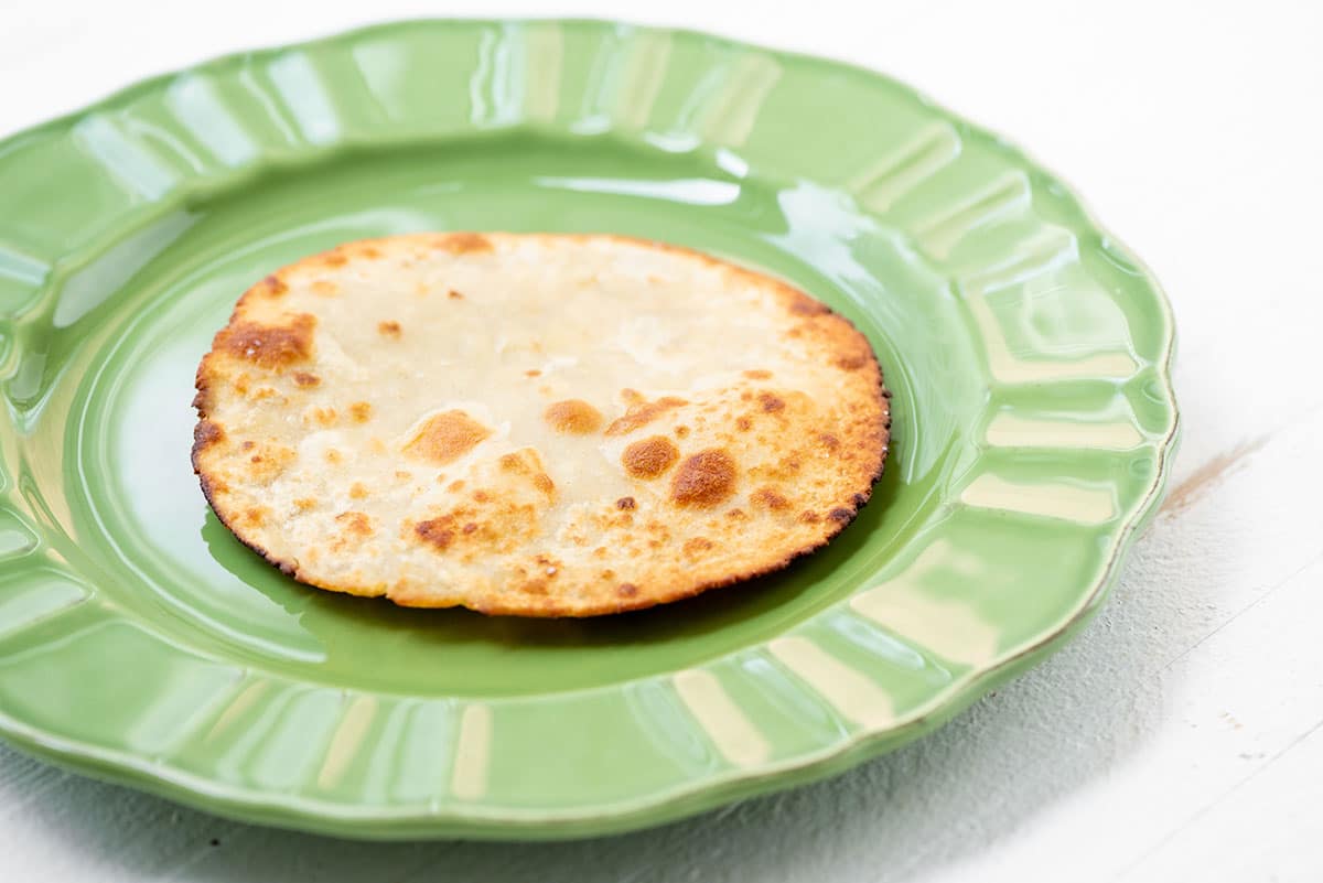 Fried tortilla on green plate.