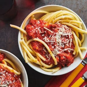 Instant Pot meat sauce on top of spaghetti in white bowls.