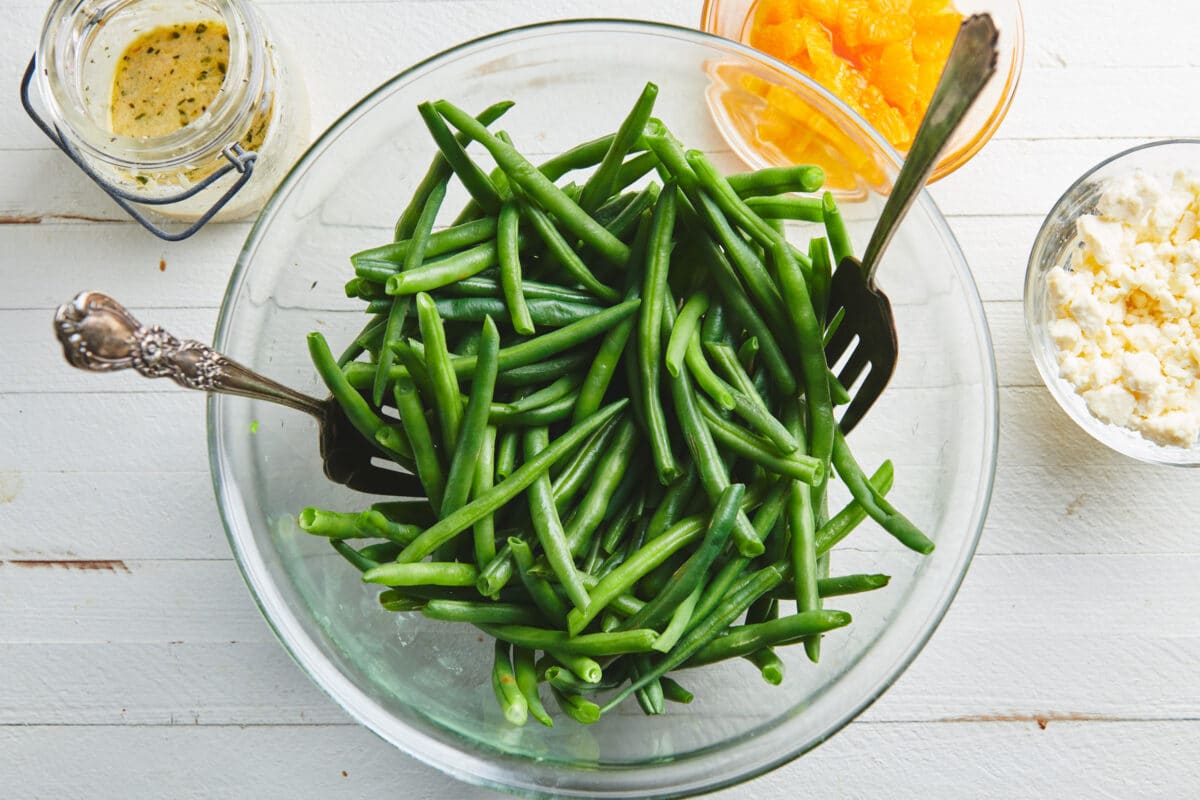Blanched green beans in large glass bowl on table.