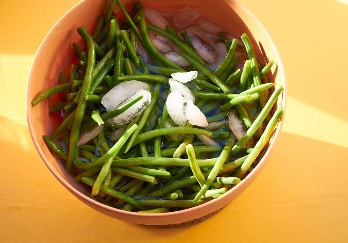 Blanched green beans in ice water bath.