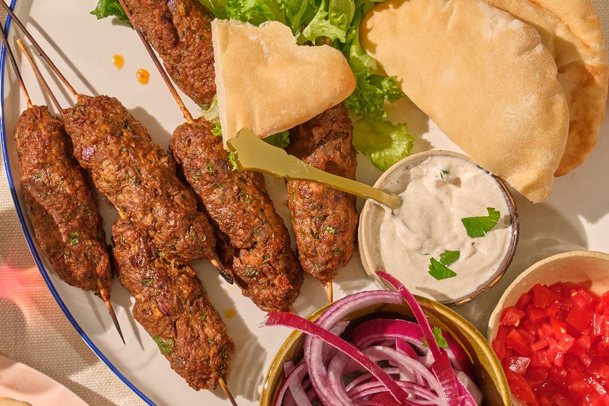 Lamb koftes on patter with pita, onions, lettuce, and garlic yogurt sauce.