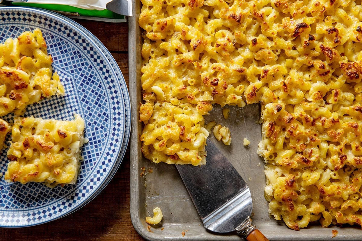 Spatula grabbing a Sheetpan Macaroni and Cheese Square from a baking pan.
